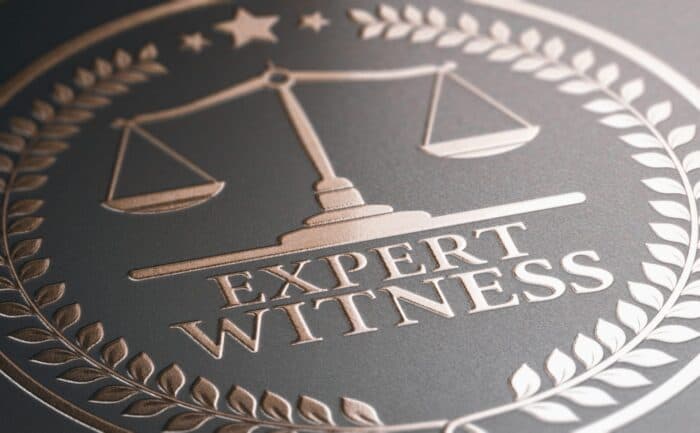 Expert Witness emblem with scales of justice symbol.